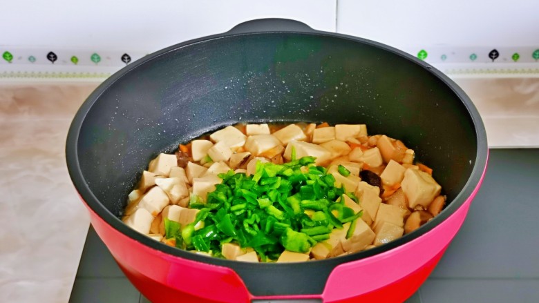 香菇炖豆腐,打开盖子加入胡萝卜与青椒。