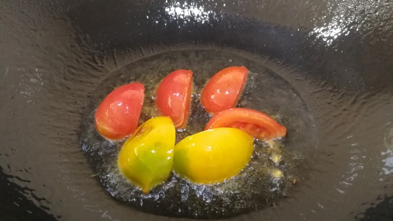 手撕包菜,热锅倒入适量油，油热放入一半的番茄，炒香。