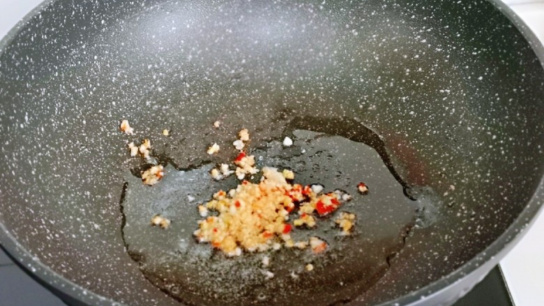 荷兰豆炒虾仁,起油锅，加入蒜辣椒碎炒香。