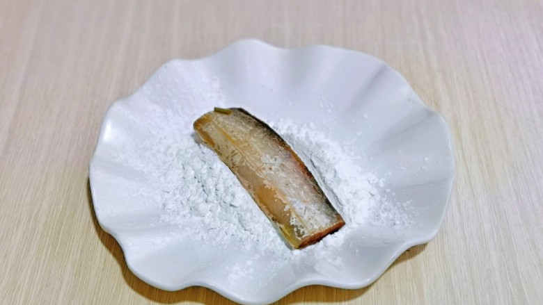 椒盐带鱼,玉米淀粉放入盘中，取一段腌制好的带鱼，均匀裹上淀粉，依次做完。