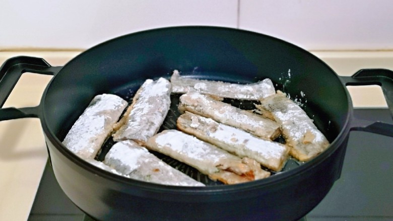 椒盐带鱼,起油锅，将带鱼摆放在平底锅中。(建议使用不粘锅呦)