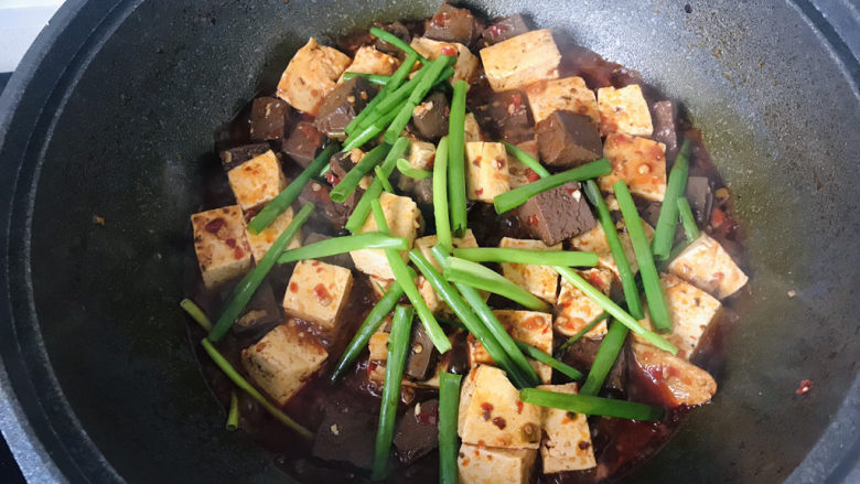 鸭血豆腐,待汤汁收到锅底，放入葱绿翻炒；