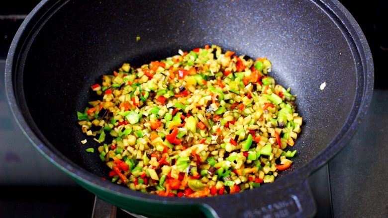 茄丁牛肉青椒包,加入切碎的青红辣椒，继续翻炒至茄丁变软即可关火盛出。