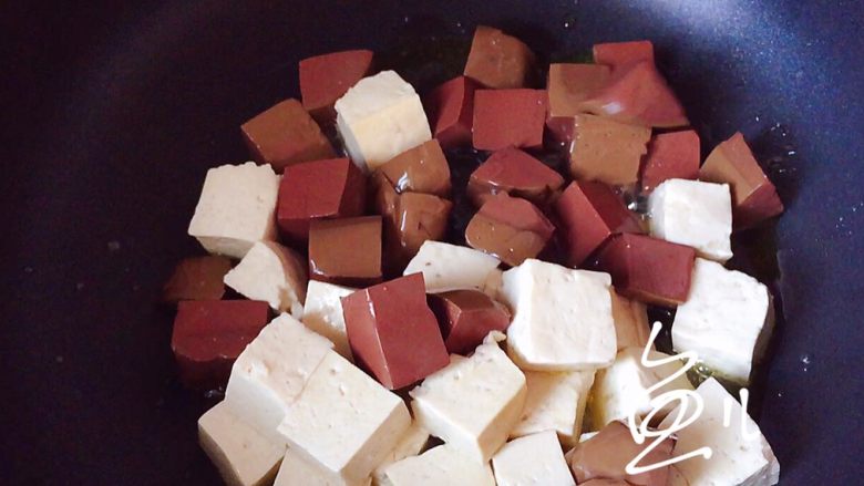 鸭血豆腐,油锅烧热，放入豆腐和鸭血翻炒几下