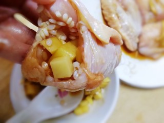 糯米蒸鸡翅,用勺子把混有糯米的土豆块塞进翅中里，填满。