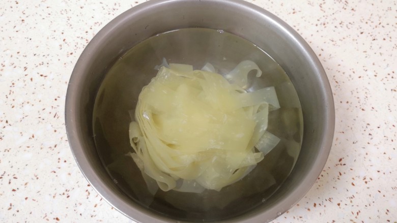 黄瓜拌面皮,加入没过面皮的开水，盖上盖子泡5分钟左右，将红油面皮里面的酱料包放在盖子上一起加热一下。
