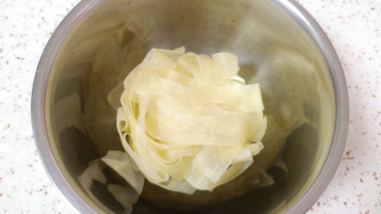 黄瓜拌面皮,打开包装，将面皮取出，放入深一点的容器里面。
