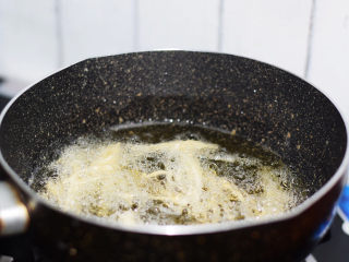 油炸金针菇,锅中倒入适量的食用油烧至6成热，放入金针菇炸3分钟定型后