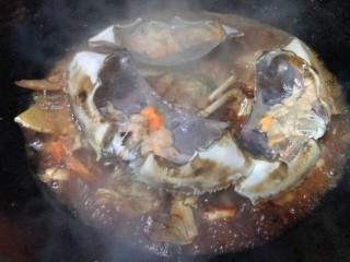 红烧梭子蟹,依次加入料酒，生抽，老抽，蚝油，糖，盐，翻炒4分钟后，加入适量热水，再把蟹盖放在上面，盖锅盖焖一会儿