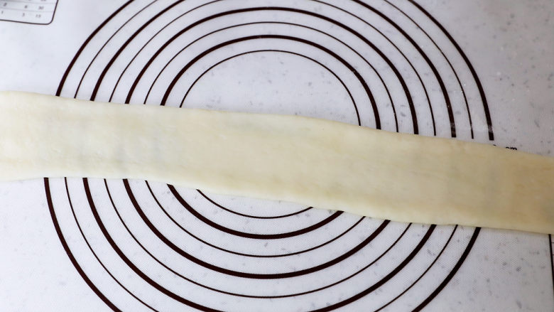 糯米凉糕,硅胶垫上撒上干粉，将糯米面团擀成长条