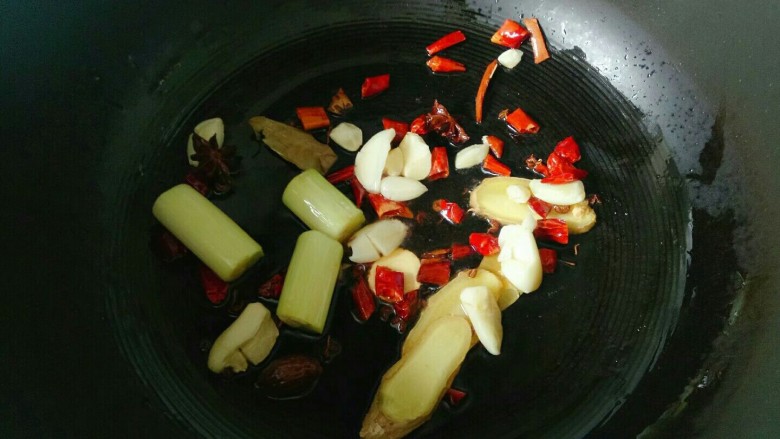 麻辣鸭头,炒锅中加入两勺花生油烧热，放入大葱段，姜片，干红辣椒，香料爆香