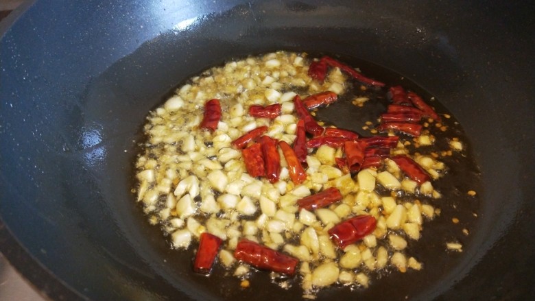 香菇炒豇豆,锅中倒入适量油烧热倒入蒜末，干辣椒。