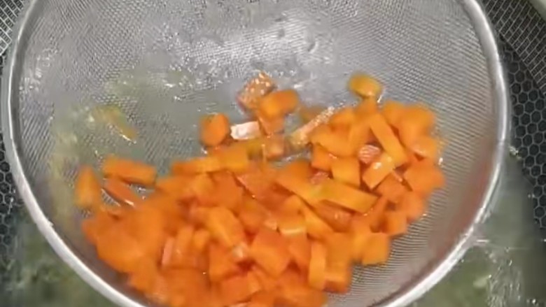 玉米炒虾仁,接着再下入胡萝卜焯水过后捞出。