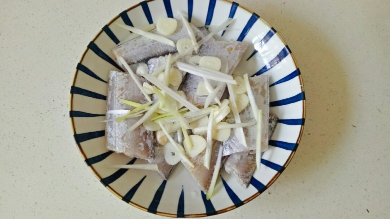 椒盐带鱼,把清洗干净的带鱼段放入盘中，加入葱姜蒜