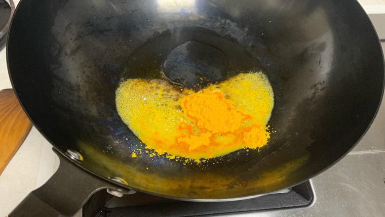 蛋黄焗苦瓜,倒入蛋黄粉，快速小火翻炒