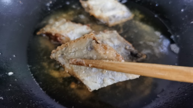 椒盐带鱼,炸到带鱼定型且微微发黄时，把鱼块捞出。