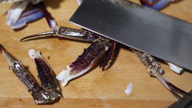 红烧梭子蟹,将冲洗干净的梭子蟹沥干水，掰掉蟹脚，用刀背拍一拍，便于入味