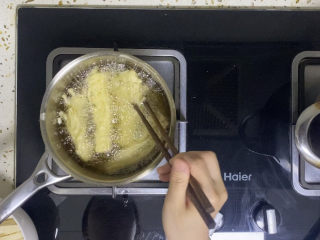 油炸金针菇,炸的过程中要注意翻动，防止粘连在一起