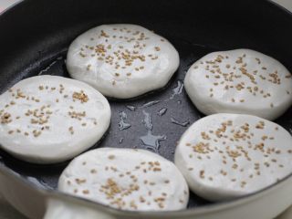 紫薯芝麻饼,平底锅刷适量食用油，依次放入饼胚用小火煎制。