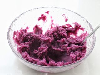 紫薯芝麻饼,取出蒸好的紫薯碾压成紫薯泥，如果太干可以加入适量牛奶调和。
