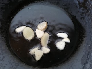毛豆炒鸡丁,锅内放油烧热放入蒜片和生姜