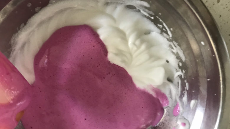 宝宝火龙果甜甜圈🍩,取1/3的蛋白霜到火龙果糊中翻拌均匀，再全部倒入蛋白霜中，同样的手法翻拌均匀