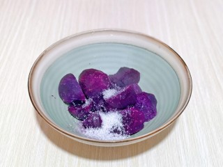 紫薯芝麻饼,取出蒸熟的紫薯，放入碗中，加入白砂糖。(也可以不加，可以根据个人喜好来)
