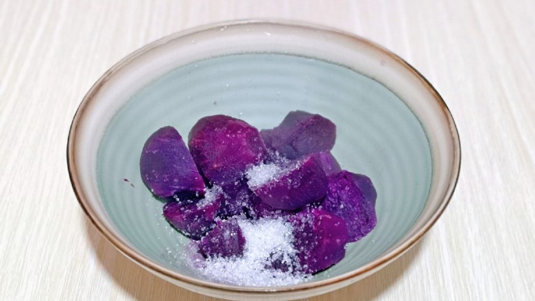 紫薯芝麻饼,取出蒸熟的紫薯，放入碗中，加入<a style='color:red;display:inline-block;' href='/shicai/ 869'>白砂糖</a>。(也可以不加，可以根据个人喜好来)