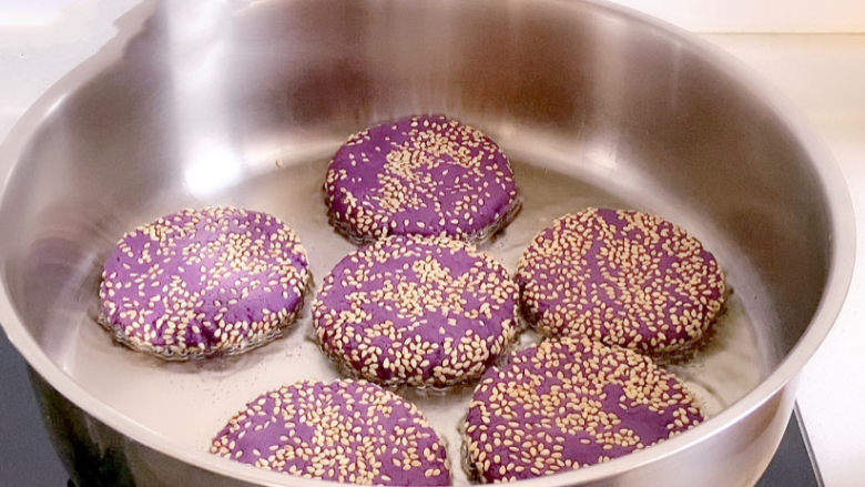紫薯芝麻饼,下入紫薯饼慢慢煎。记得翻面。