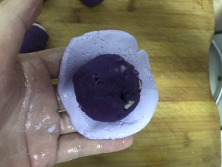 紫薯芝麻饼,取一个小剂子，用手压成圆形饼状包入紫薯球