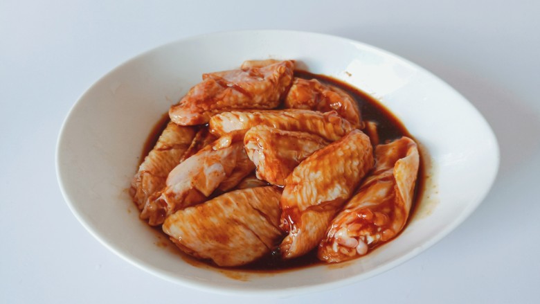 干锅麻辣鸡翅,带上手套把鸡翅与调味料抓均匀。