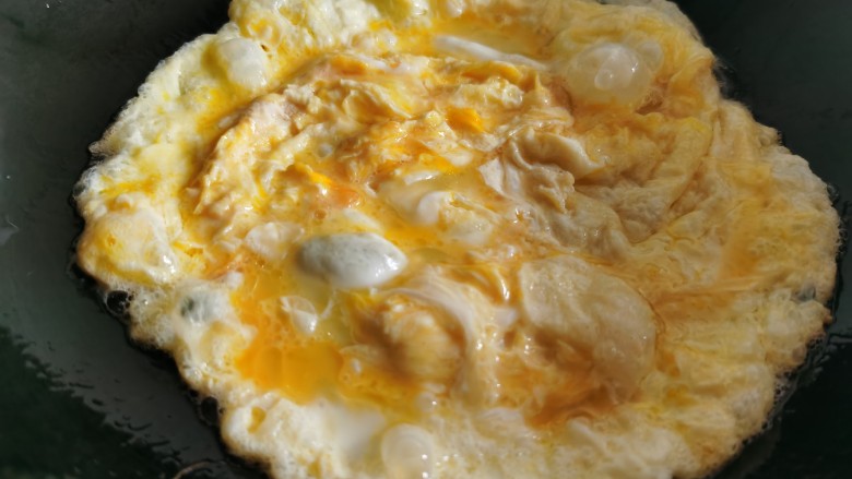 金针菇炒蛋,炒锅烧热放油，倒入蛋液，翻炒至蛋液凝固后盛出来。