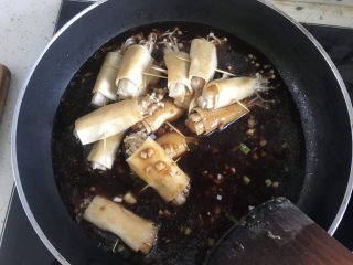 豆皮金针菇卷,料汁煮开下入金针菇