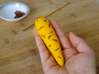 胡萝卜馒头,可可粉用水稍微稀释一下，用竹签蘸点可可粉在黄色面团上扎几个孔。


