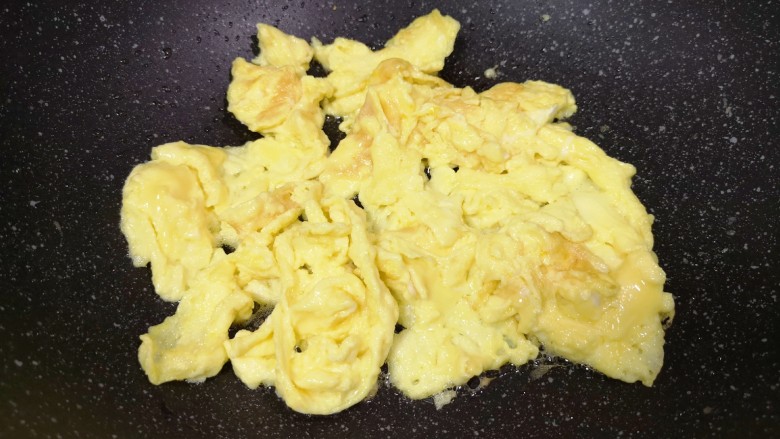 金针菇炒蛋,将鸡蛋快速炒熟盛出备用。
