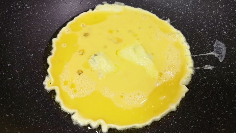 金针菇炒蛋,炒锅内倒适量的食用油烧热，倒入蛋液。