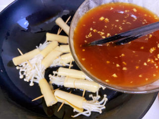 豆皮金针菇卷,酱汁再用筷子搅拌一下，然后倒入锅中。