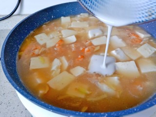 虾仁豆腐羹,加点盐调味，淋上水淀粉，一边倒一边用勺子搅拌均匀。
