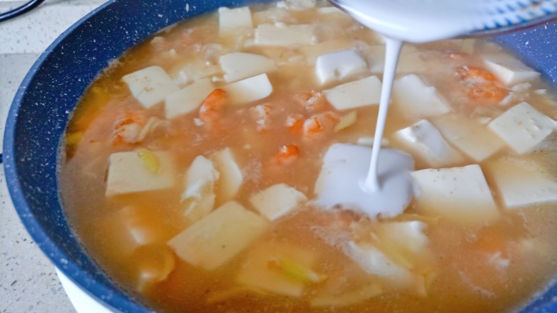 虾仁豆腐羹,加点盐调味，淋上水淀粉，一边倒一边用勺子搅拌均匀。