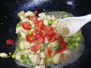 毛豆炒鸡丁,放入甜红椒，少许胡椒粉，简单翻炒均匀即可。
