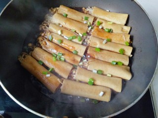 豆皮金针菇卷,焖煮2分钟，撒些葱花装饰即可