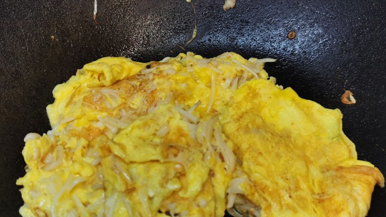 金针菇炒蛋,锅铲顺时针转动，待蛋液凝固，熟了即可上碟。