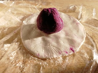 紫薯芝麻饼,揭开上面的保鲜膜，放入紫薯球。