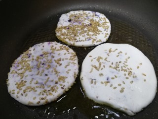 紫薯芝麻饼,平底锅倒入适量油，中小火放入小饼。