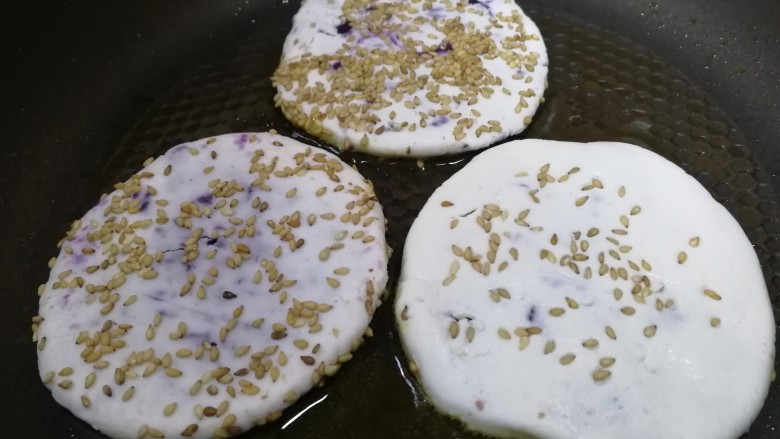 紫薯芝麻饼,平底锅倒入适量油，中小火放入小饼。
