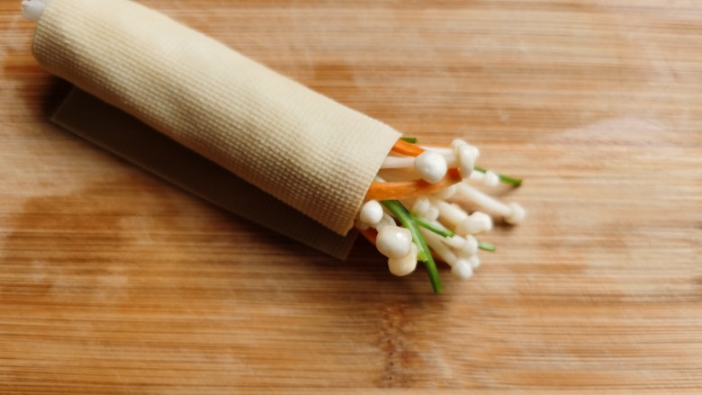 豆皮金针菇卷,把豆皮卷起来，卷的时候一定要卷紧，防止烹饪时散掉。