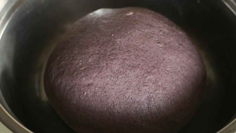 红糖花卷（黑米版）,揉成光滑的面团后滚圆，盖保鲜膜发酵至2倍大（这个温度需要1小时）；