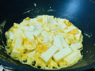 虾仁豆腐羹,加豆腐，小心翻炒豆腐，让咸蛋黄裹着豆腐