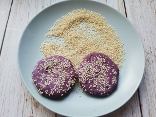 紫薯芝麻饼,搓成圆形压扁，两面粘上芝麻