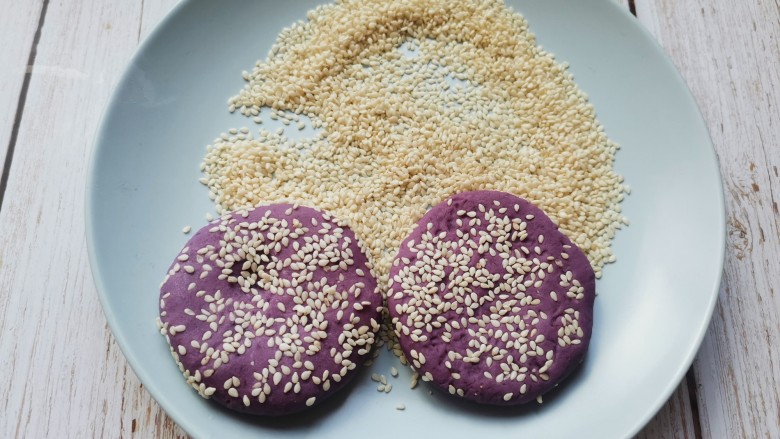 紫薯芝麻饼,搓成圆形压扁，两面粘上芝麻